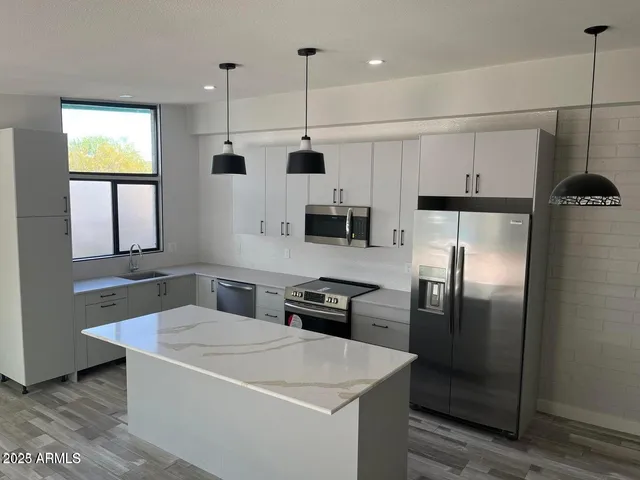 a kitchen with stainless steel appliances a refrigerator sink and microwave