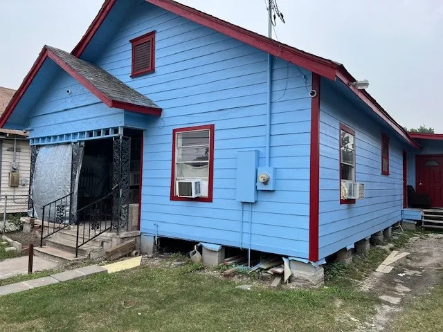 a view of a house with a small yard and wooden fence