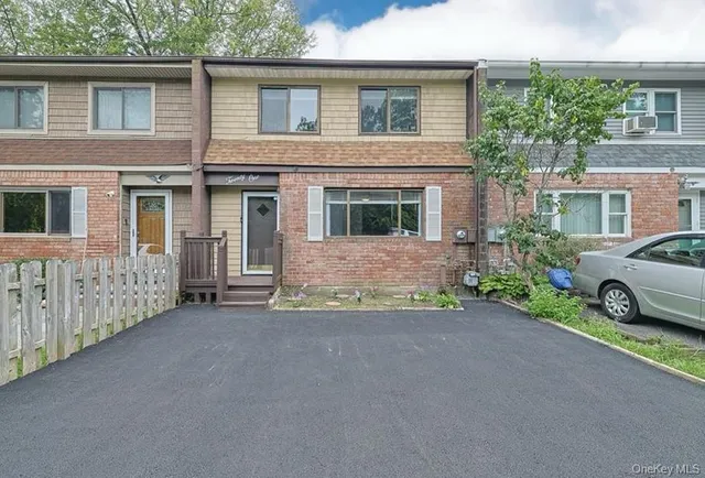 a view of a house with a yard and parking space