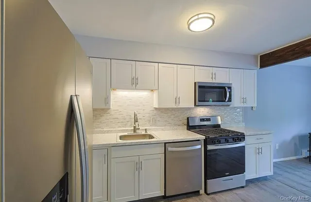 a kitchen with stainless steel appliances granite countertop a sink and a stove top oven