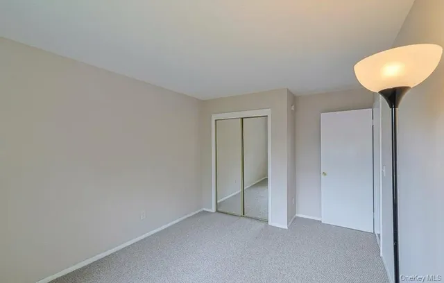 a view of an empty room and chandelier fan