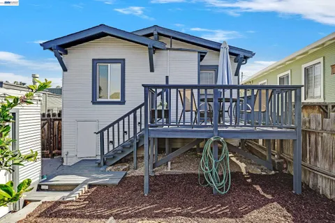 a view of a house with wooden deck and furniture