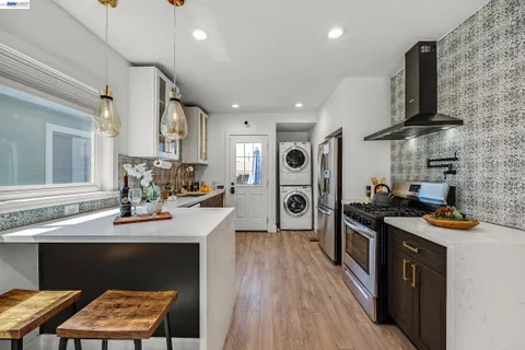 a kitchen with stainless steel appliances a stove sink and wooden floor