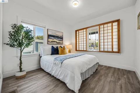 a bed sitting in a spacious bedroom next to a window