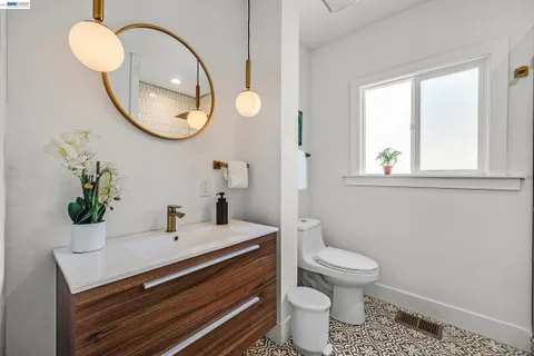 a bathroom with a granite countertop toilet sink and mirror