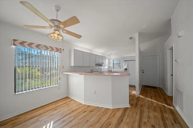 a kitchen with kitchen island wooden floor and window