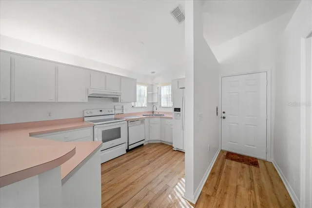 a kitchen with white cabinets and white appliances
