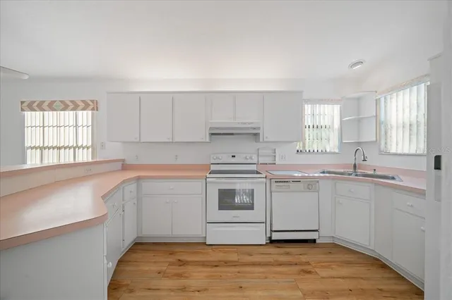 a kitchen with a sink cabinets stainless steel appliances and window