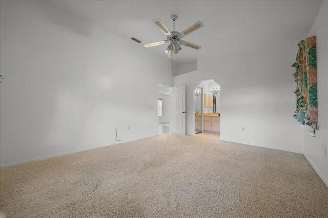 en empty room with windows and fan