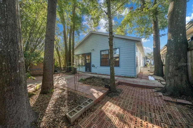 a view of a yard in front of a house with large trees
