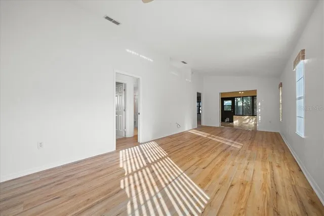 a view of empty room with wooden floor