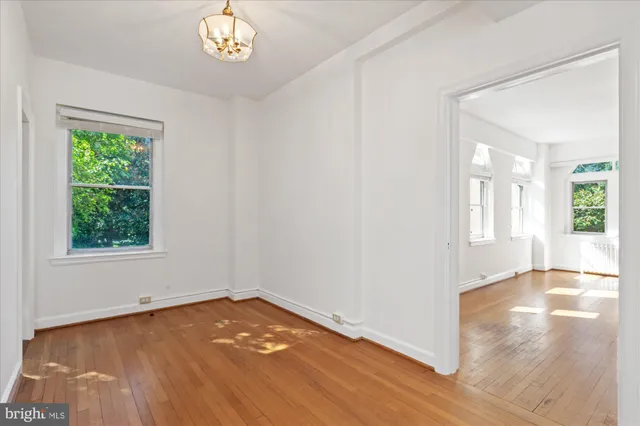 a view of empty room with window and wooden floor
