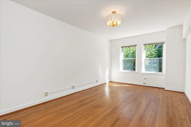 an empty room with a window and wooden floor
