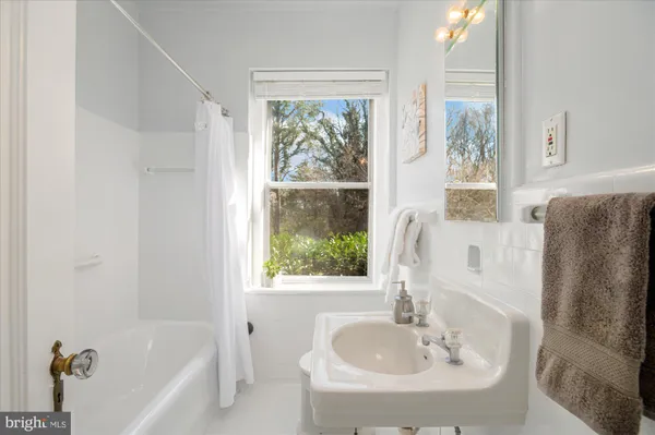 a bathroom with a tub sink and mirror