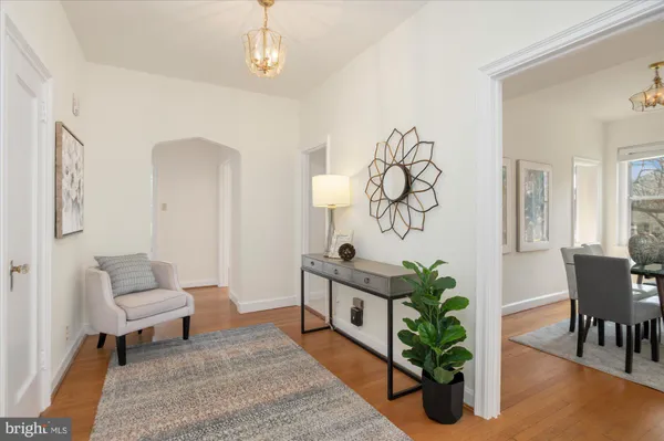 a living room with furniture flowers and wooden floor