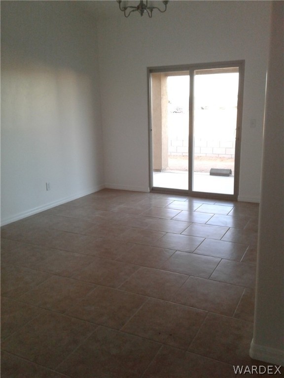 3641 North Kenneth Road Kingman, AZ 86409 - Photo 8 of 34 an empty room with wooden floor and windows
