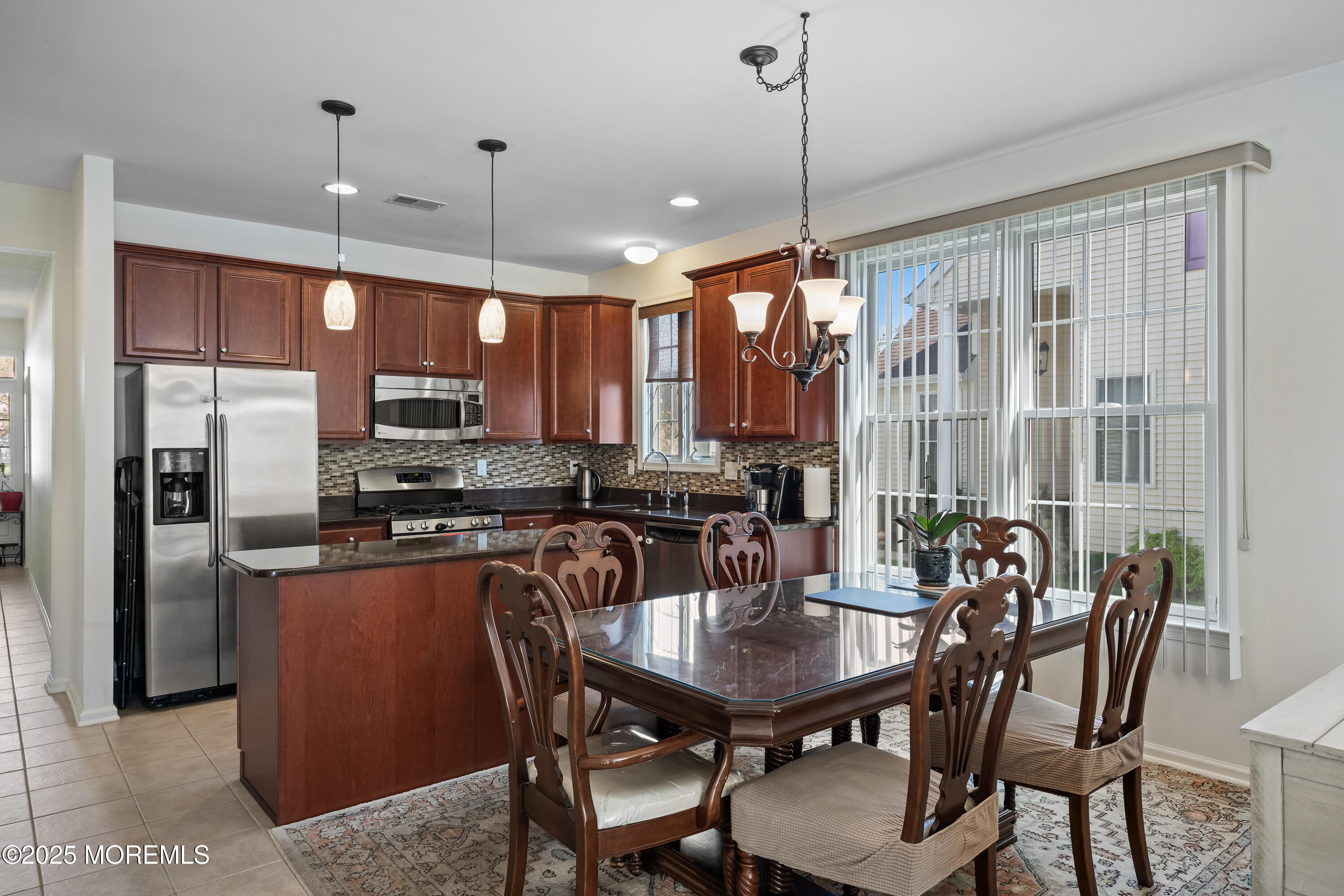 67 Sequoia Parkway Asbury Park, NJ 07712 - Photo 5 of 38 a kitchen with a dining table chairs stainless steel appliances and cabinets