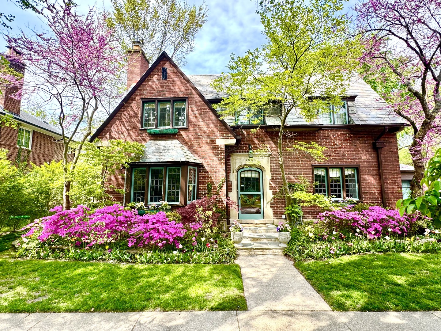 a front view of a house with yard and fountain