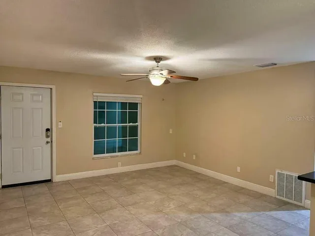 an empty room with windows and cabinet