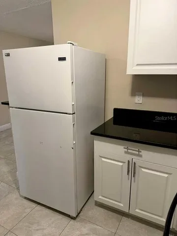 a white refrigerator freezer sitting in a kitchen