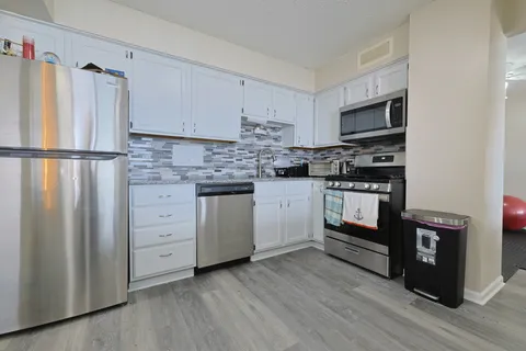 a kitchen with stainless steel appliances a refrigerator sink and cabinets