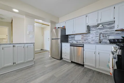 a kitchen with white cabinets and stainless steel appliances