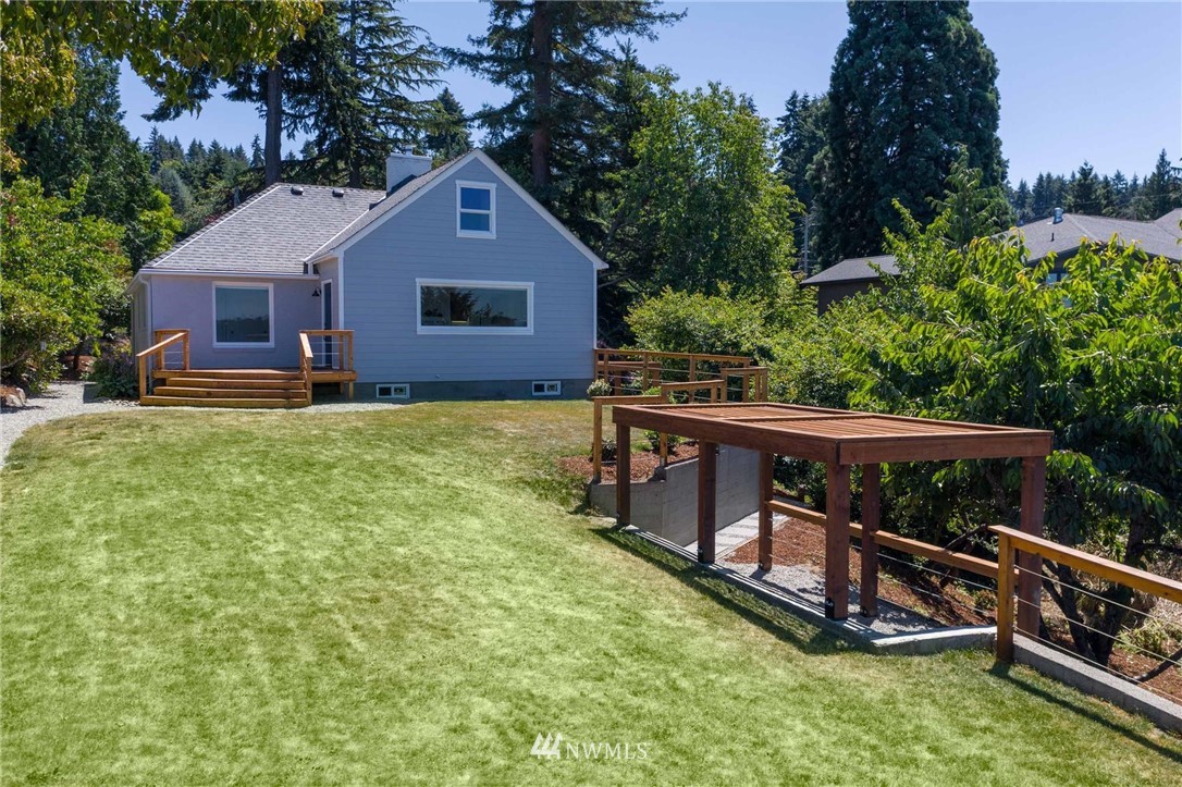 4411 Sunset Beach Road West University Place, WA 98466 - Photo 31 of 39 a view of a house with wooden deck and a yard