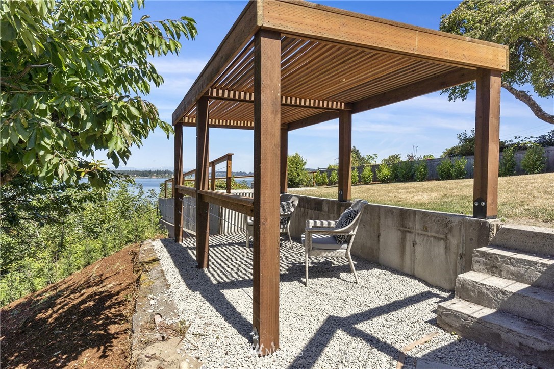 4411 Sunset Beach Road West University Place, WA 98466 - Photo 32 of 39 a view of a patio with a table chairs and backyard