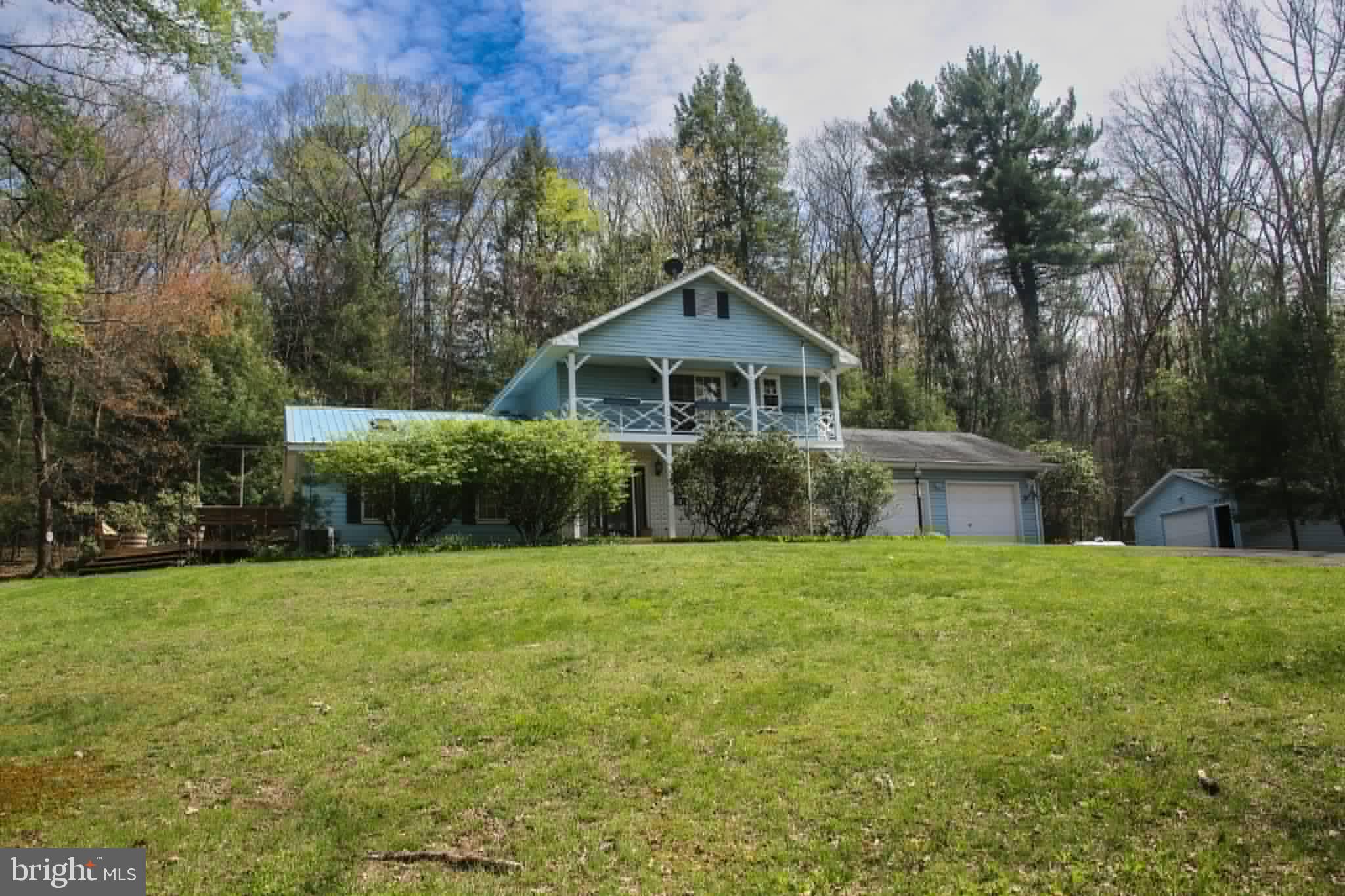 a front view of a house with a yard and trees