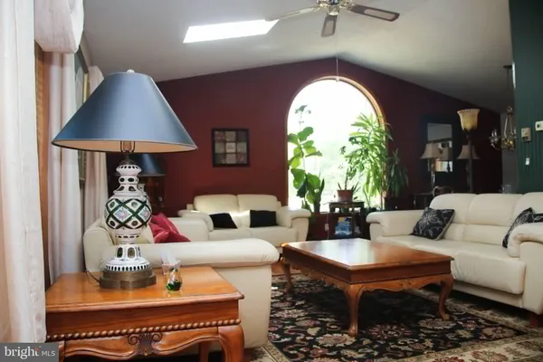 a living room with furniture a chandelier and a large window