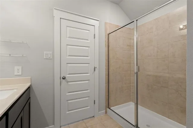 a bed sitting in a bedroom next to a window and a chandelier