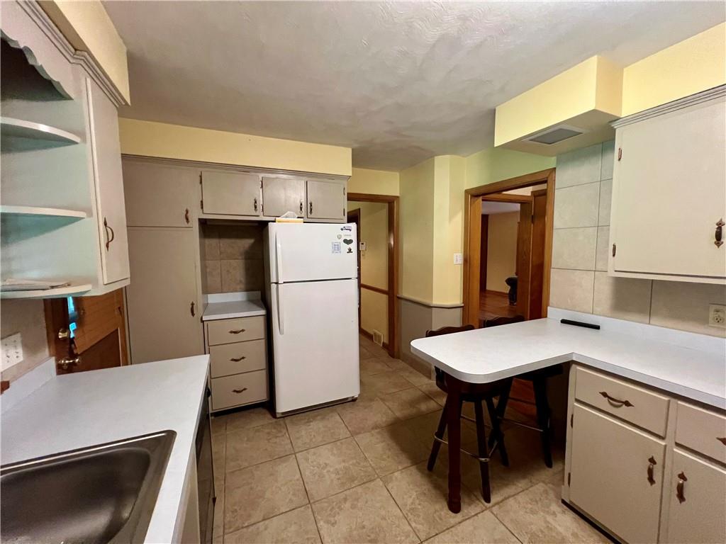 963 Kings Chapel Road New Castle, PA 16105 - Photo 15 of 27 a kitchen with a refrigerator a stove a sink and cabinets