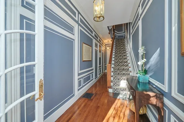a view of a brick house with plants and wooden fence