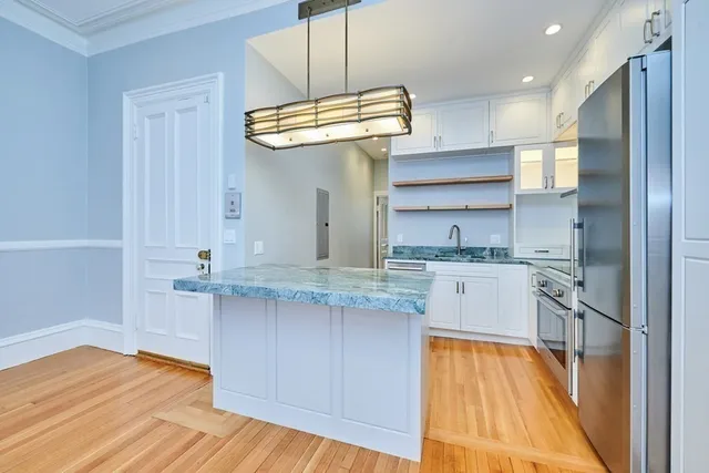 a kitchen with stainless steel appliances granite countertop a sink a stove and refrigerator