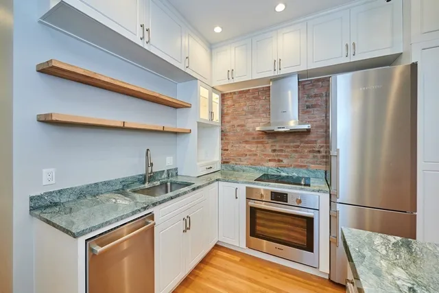 a kitchen with granite countertop stainless steel appliances and wooden floor