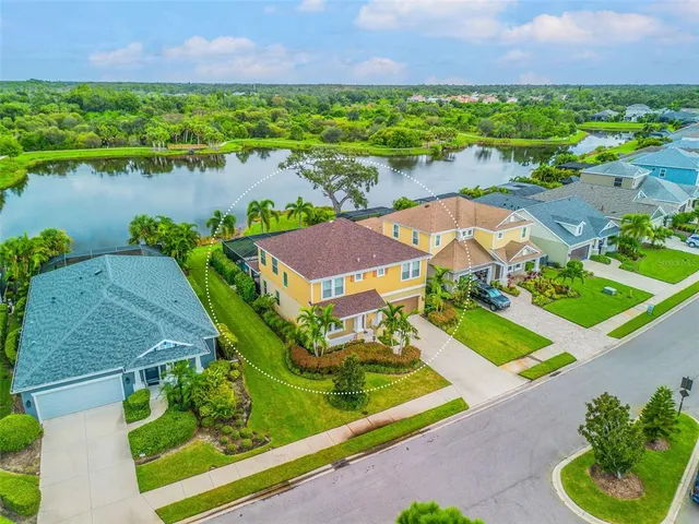 an aerial view of a house with a garden and lake view