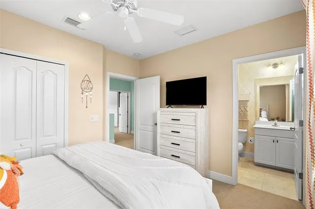 a bedroom with a large bed and a flat tv screen on dresser