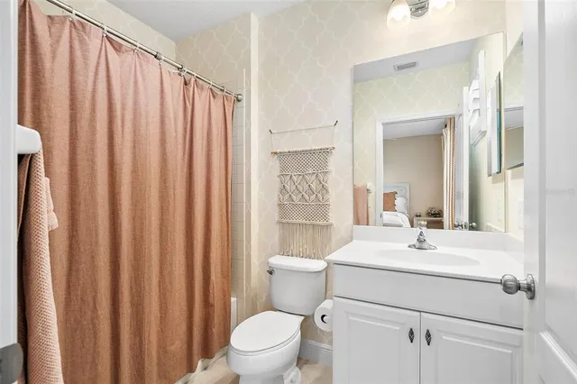a bathroom with a sink a toilet and shower curtain