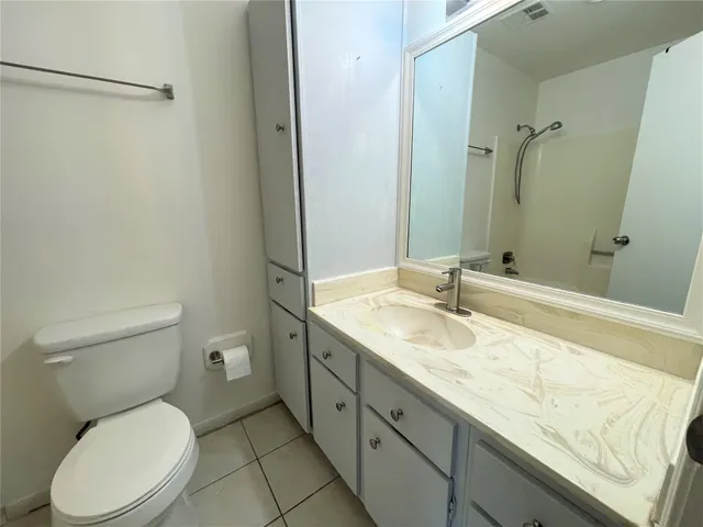 a backyard of a house with large trees and a wooden bench