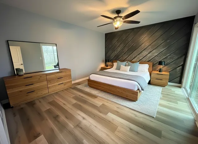 a view of empty room with wooden floor and fan