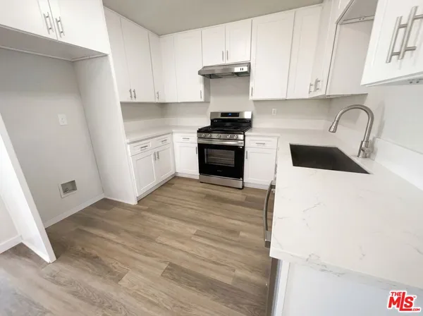 a kitchen with a sink stove and cabinets