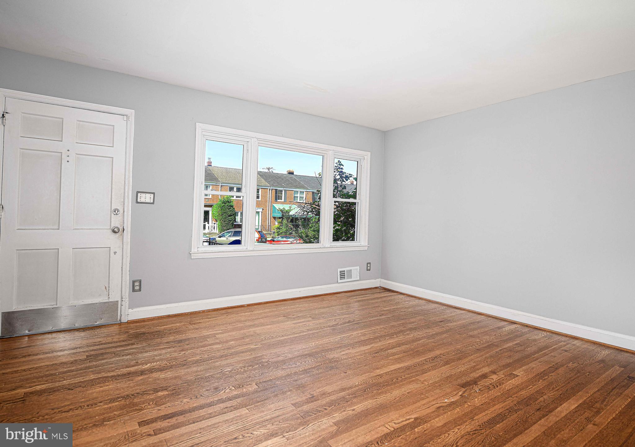 967 Radcliffe Road Baltimore, MD 21204 - Photo 6 of 26 a view of an empty room with wooden floor and a window