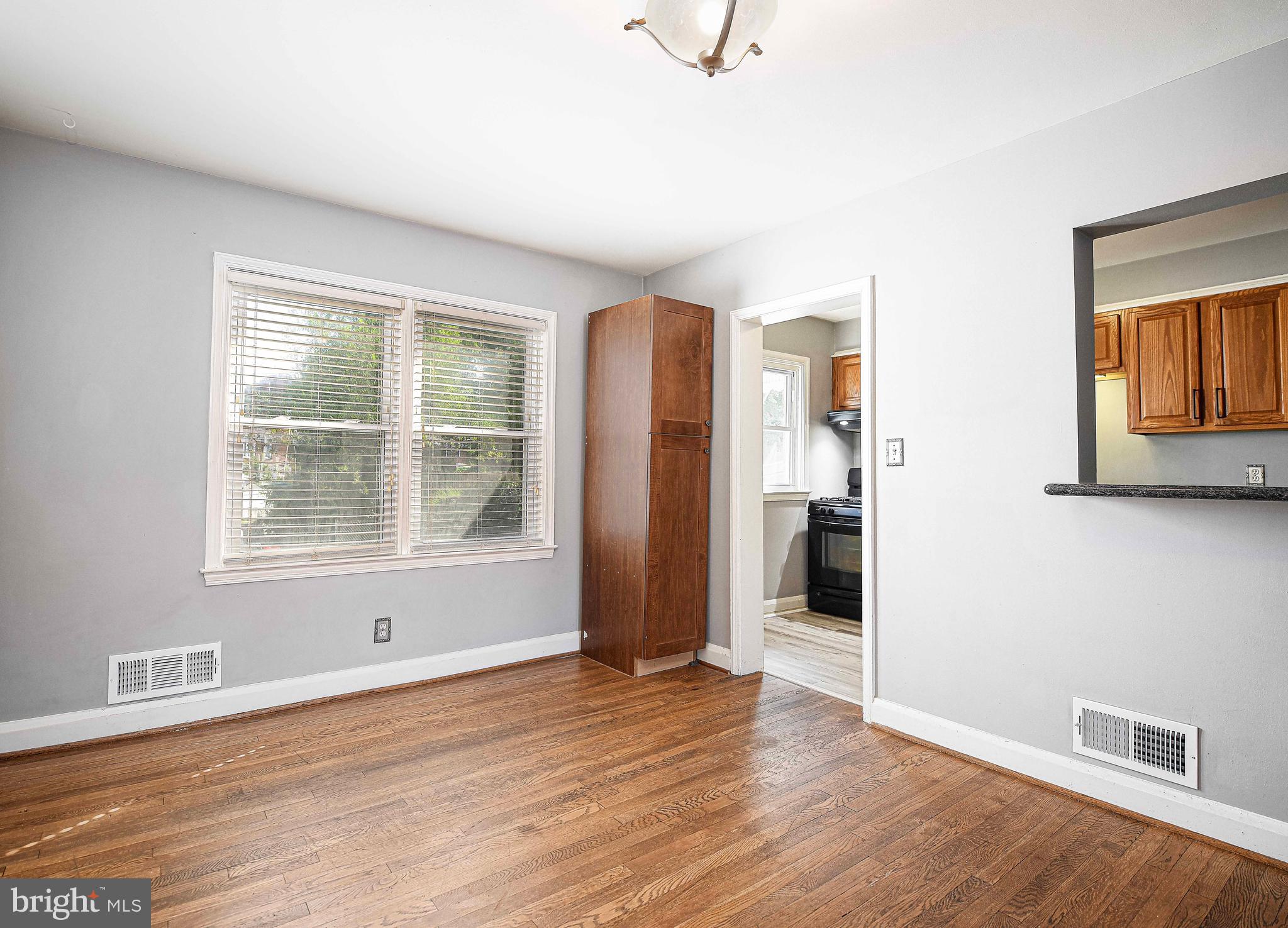 967 Radcliffe Road Baltimore, MD 21204 - Photo 9 of 26 an empty room with wooden floor and windows