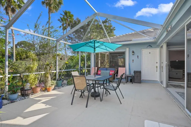 a view of a patio with a table and chairs under an umbrella