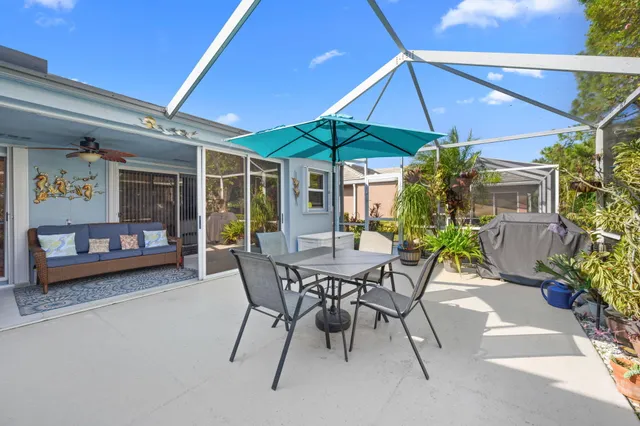 a view of a patio with a table and chairs under an umbrella