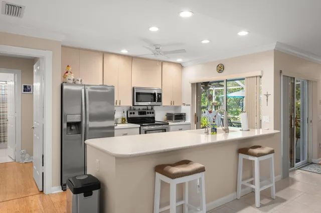 a kitchen with refrigerator a sink and chairs