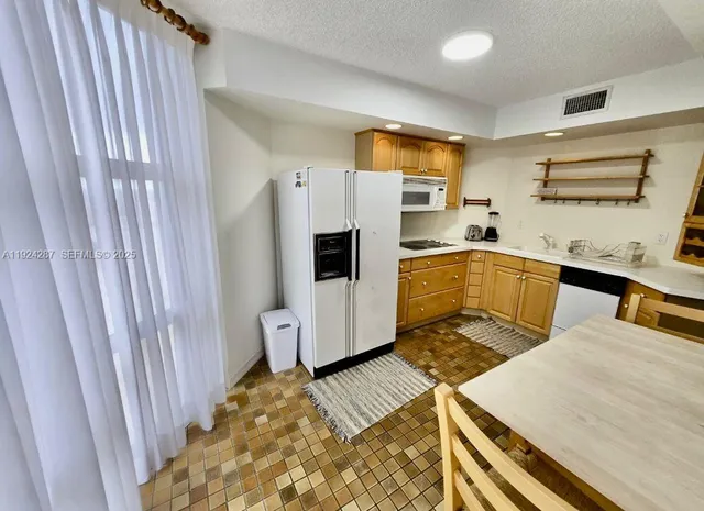 a kitchen with white cabinets and sink