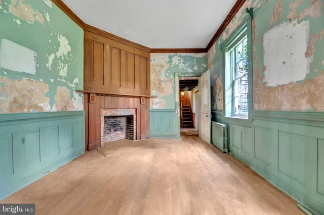 a view of an empty room with a fireplace and a window