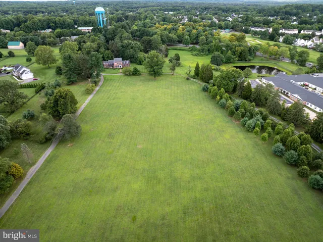 an aerial view of residential houses with outdoor space and trees
