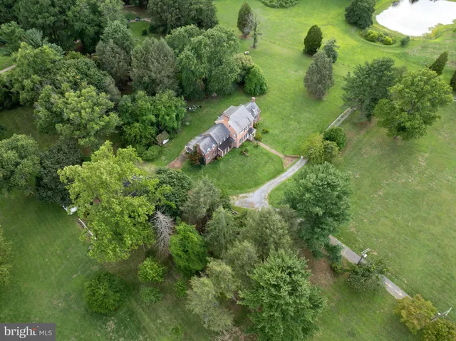 an aerial view of residential houses with outdoor space and trees all around